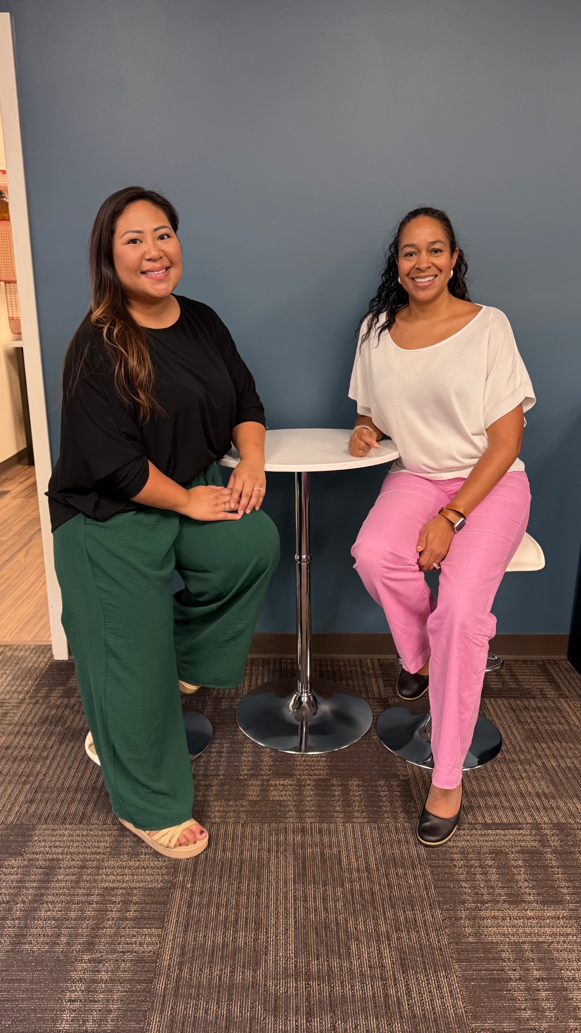 HER Influence co-founders seated together at a small table